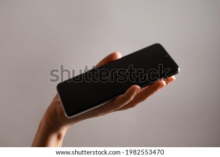 Slim modern smartphone in a woman's hand, use the Internet or apps on your phone.