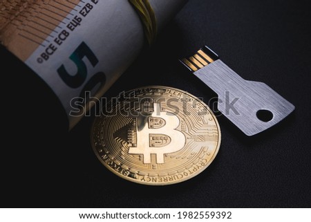 Bitcoin coin, usb memory card in the form of a key and a roll of money. Soft focus.
