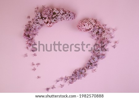 Fresh branches of purple lilac blossoms on light pastel purple background. Empty place for text. Flat lay.