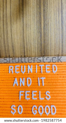 Reunited and it Feels So Good Pandemic Welcome Back Sign with Wooden Background