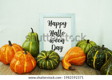 Happy Halloween Day typography text with pumpkin decoration on wooden table