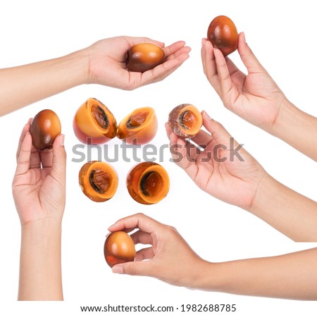 Collection of hand holding Preserved duck eggs isolated on white background.