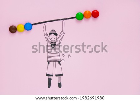 An illustration of a boy lifting dumbbells from real colorful candies
