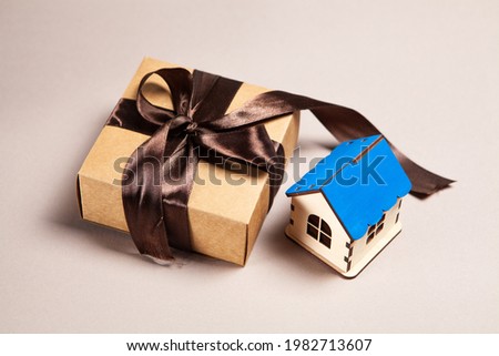 gift box and house on a pink background. buying a house