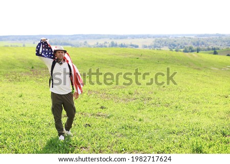 Man waving American flag standing in farm agricultural field , holidays, patriotism, pride, freedom, political parties, immigrant