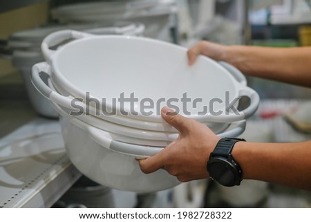 Male hand hold Plastic bucket in kitchen. Home furniture and decoration concept