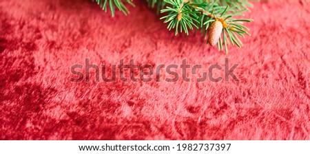 Christmas background, green pine branches on a red velvet festive background. Creative composition with border and copy space, top view. New year, holiday, christmas, decoration.