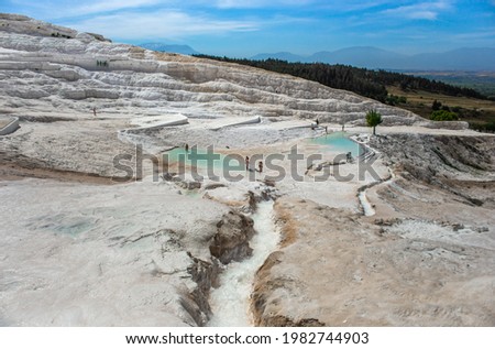 Carbonate mineral cliff with calcite-laden waters in Hierapolis Pamukkale in Turkey. Pamukkale is meaning cotton castle in Turkish, is a natural site in Denizli Province.