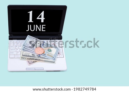 14th day of june. Laptop with the date of 14 june and cryptocurrency Bitcoin, dollars on a blue background. Buy or sell cryptocurrency. Stock market concept. Summer month, day of the year concept.