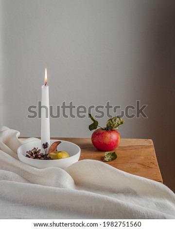 Still life Candle and apple on the wooden table autumn slow living simplicity nature home cozy. High quality photo