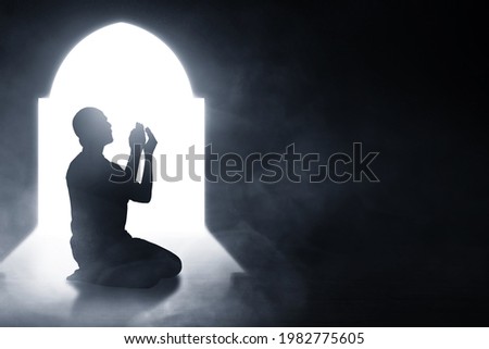 Silhouette of muslim man praying Royalty-Free Stock Photo #1982775605