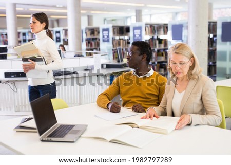 Professor and students communicate in the library. High quality photo