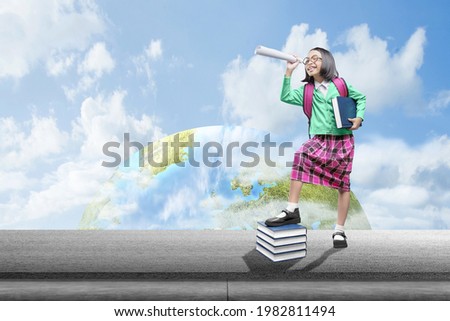 Asian little girl with backpack and binoculars with a blue sky background. World Children Day