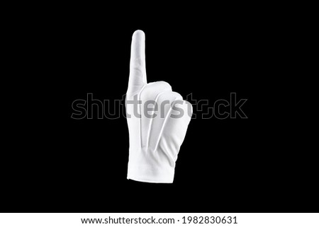 Brush, Hand in a white glove isolated on a black background, shows the index finger. Concept human gesture direction, idea, attention, one