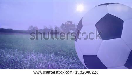Composition of football on white line on grass pitch. sport and fitness concept digitally generated image.