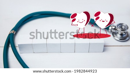 Composition of heart icons over stethoscope and white blocks with copy space on white background. medicine and healthcare concept digitally generated image.