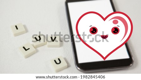 Composition of smiling heart icon over smartphone and i luv u text on white squares. love and technology concept digitally generated image.