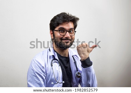 A Doctor with wired smile Pointing thumb Towards Side