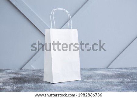 Paper bag on table against light background