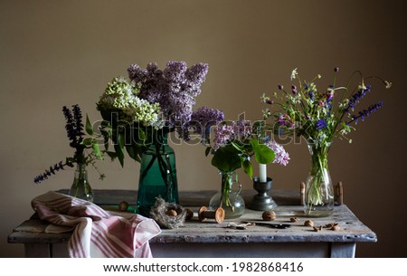 bouquets of lilacs and wildflowers on a vintage  table.still life in retro style