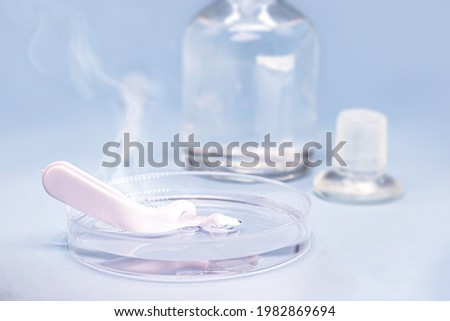Sulfuric acid in petri dish, melting plastic spoon, corrosive acid in action Royalty-Free Stock Photo #1982869694