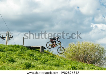 Mountain biker is jumping from the drop Royalty-Free Stock Photo #1982876312