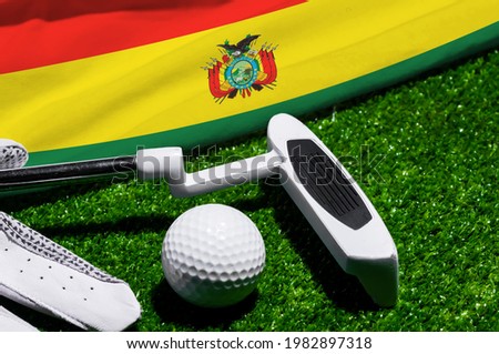 Golf ball and club with flag of Bolivia on green grass. Golf championship in Bolivia