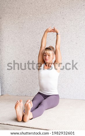 Active lifestyle. Young attractive woman wearing sportswear practicing yoga at home. Indoor full length, gray background