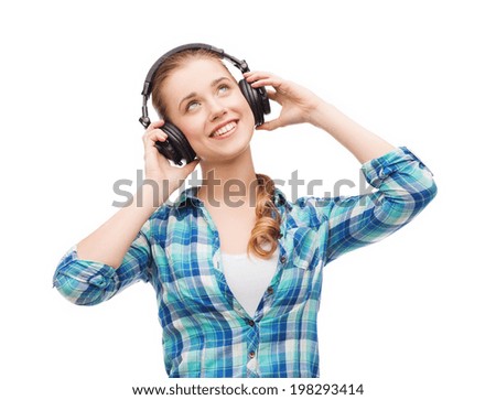 music and technology concept - smiling young woman listening to music in headphones