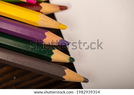 Colored pencils on a wooden table. Close-up, selective focus. Self-development during self-isolation in the covid-19 pandemic.