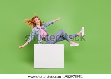 Full size profile side photo of young excited girl happy positive smile playful hands wings fly isolated over green color background