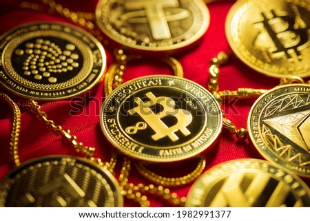 Close up golden cryptocurrency coin on the red cloth.