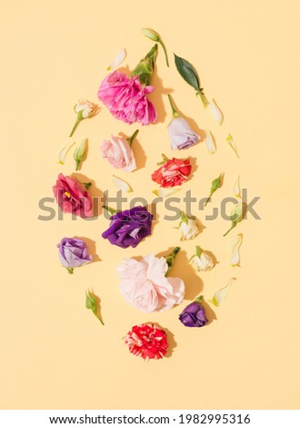 Red, pink and violet flowers arranged on yellow background. Fresh soft spring concept. Flat lay.