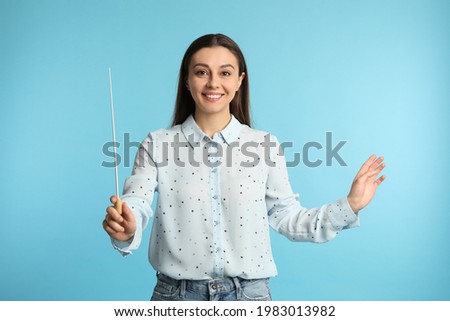 Music teacher with baton on turquoise background Royalty-Free Stock Photo #1983013982