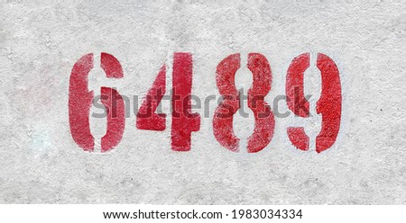 Red Number 6489 on the white wall. Spray paint.
