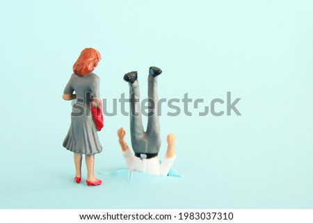 woman looking at clumsy man. funny concept of married couple or romantic relationship Royalty-Free Stock Photo #1983037310