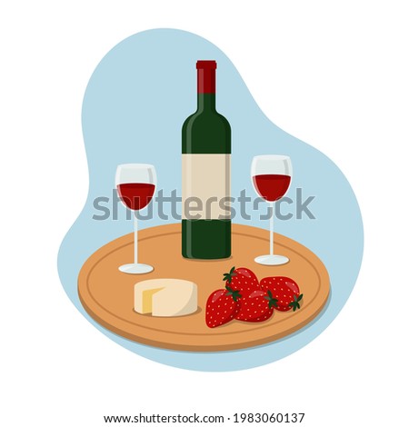 Bottle of wine, wineglasses, strawberries and cheese on chopping board. 