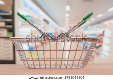 Empty shop basket on blurring supermarket aisle background
