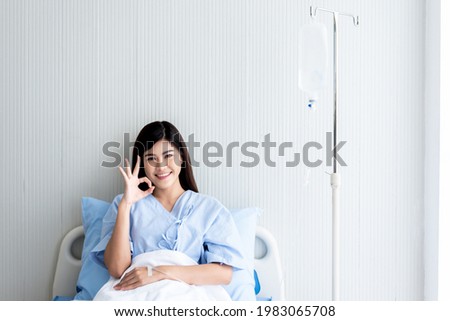 Portrait images of Asian attractive woman patient sitting in patient's bed, having good treatment satisfaction, with white background, to people health care and health insurance concept.