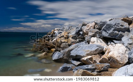 long exposure sea photo and stacked rocks by the sea 