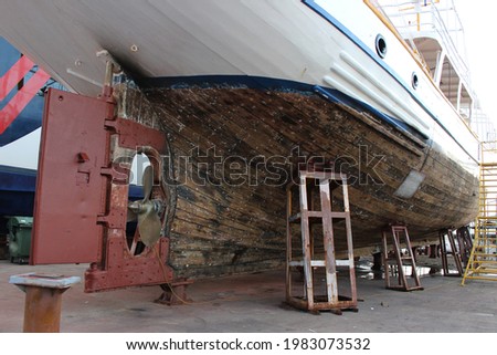 Vessel in the shipyard dry dock. Hull maintenance and shipyard ground works. Royalty-Free Stock Photo #1983073532