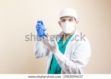 The doctor puts on gloves. On a light background. High quality photo