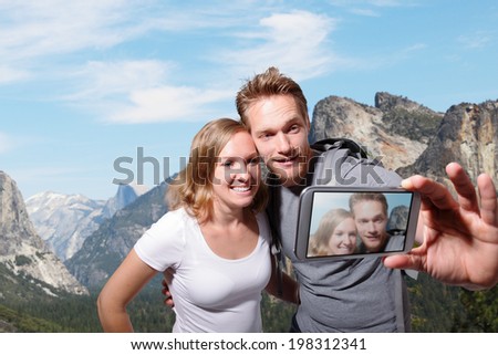 happy couple selfie by smart phone in yosemite national park, caucasian