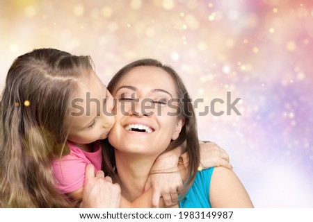 Happy woman have fun with child girl, stand behind hug kiss. Mother's Day love the family concept