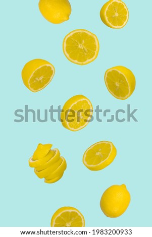 Floating levitating fresh and sliced lemon on pastel blue background. Vitamins, healthy diet concept. Minimal fruit idea. Sliced lemon floating in the air. Creative concept with flying fruits.