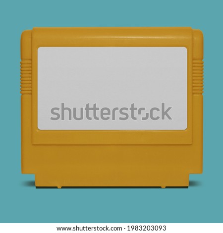 Retro TV Game cartridge in yellow plastic case on blue background. Old school gaming. Isolated