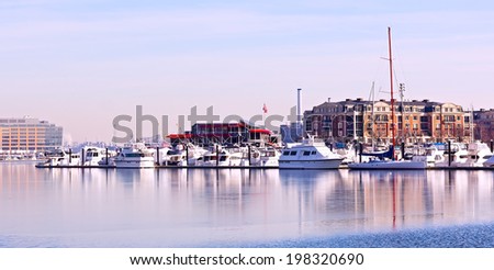 Winter landscape of Baltimore Inner Harbor. Yachts anchored at pier in winter.