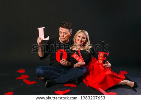Family keeps the word LOVE valentine, heart, on the floor hearts married romance. shape. dream forever, frame in red dress girl, barefoot 
