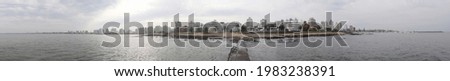 Panoramic photography of the complete skyline of Punta del Este City and a cloudy sky seen from the point of a pier