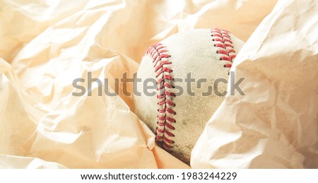 Old used baseball in wrinkles of material background for sport.